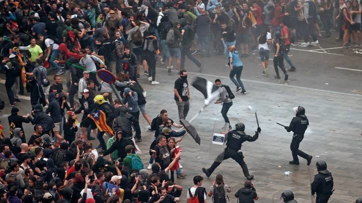 Mossos d'Esquadra cargan, ayer contra las miles de personas se agolparon ante el Aeropuerto del Prat. QUIQUE GARCÍA