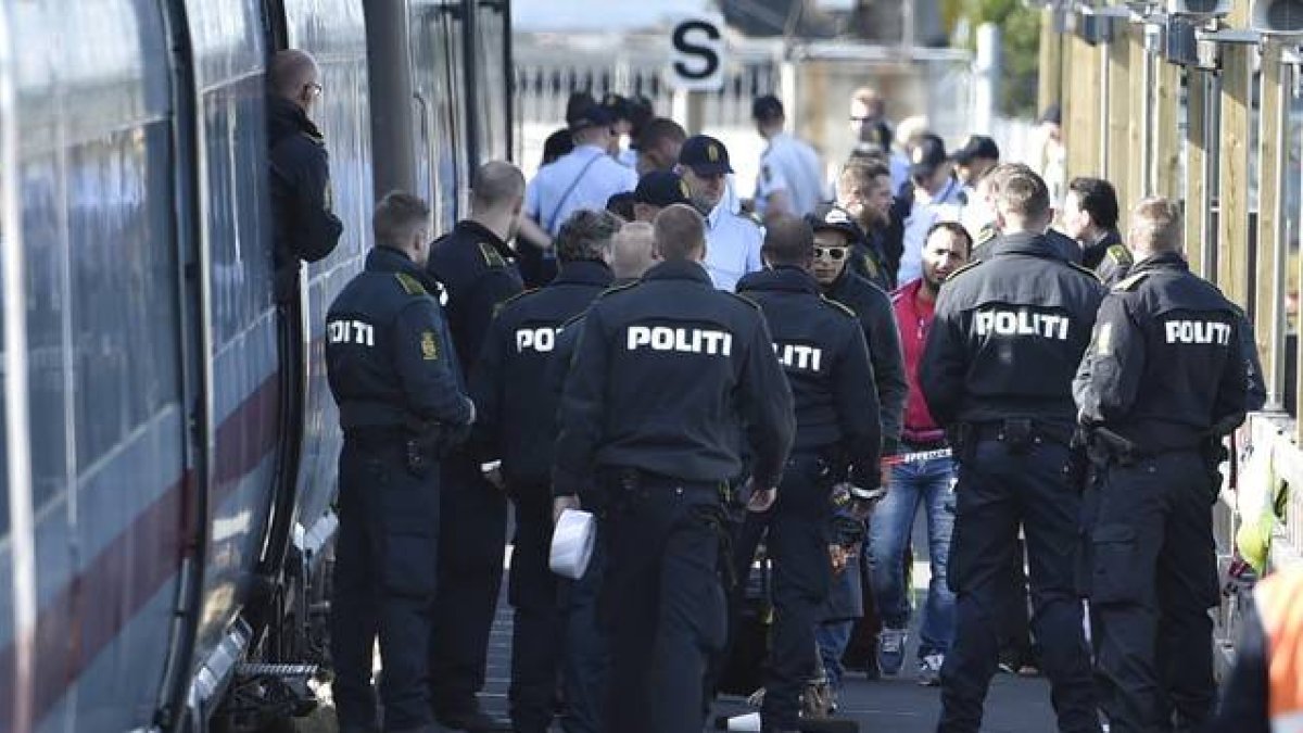 Un policía danés ante un tren donde viajajn refugiados sirios.