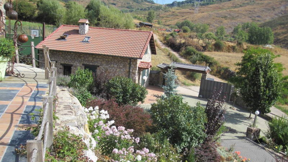 Jardines, habitación, salón con chimenea y pozo de la finca La Castañona, en Buiza de Gordón.