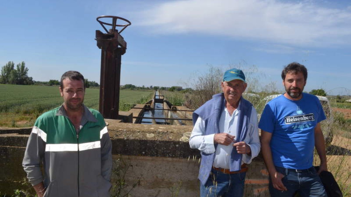Varios regantes ayer en una de las acequias de Villamañán. MEDINA