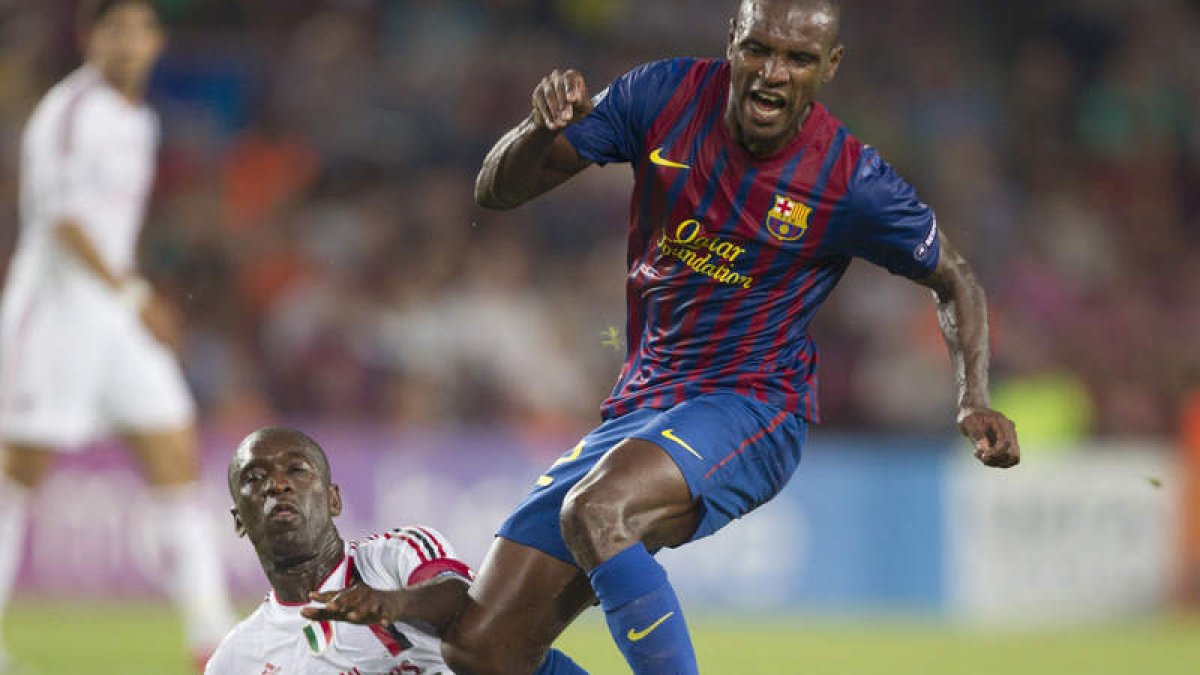 Abidal lucha por el balón con Seedorf en un partido de la Champions.
