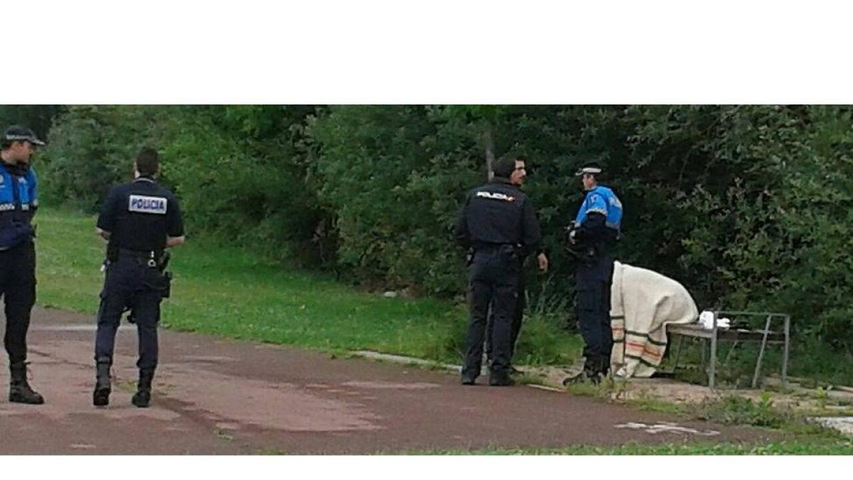 La mujer, sentada en un banco de la zona peatonal del río, por una manta y acompañada por los policías que acudieron a su rescate