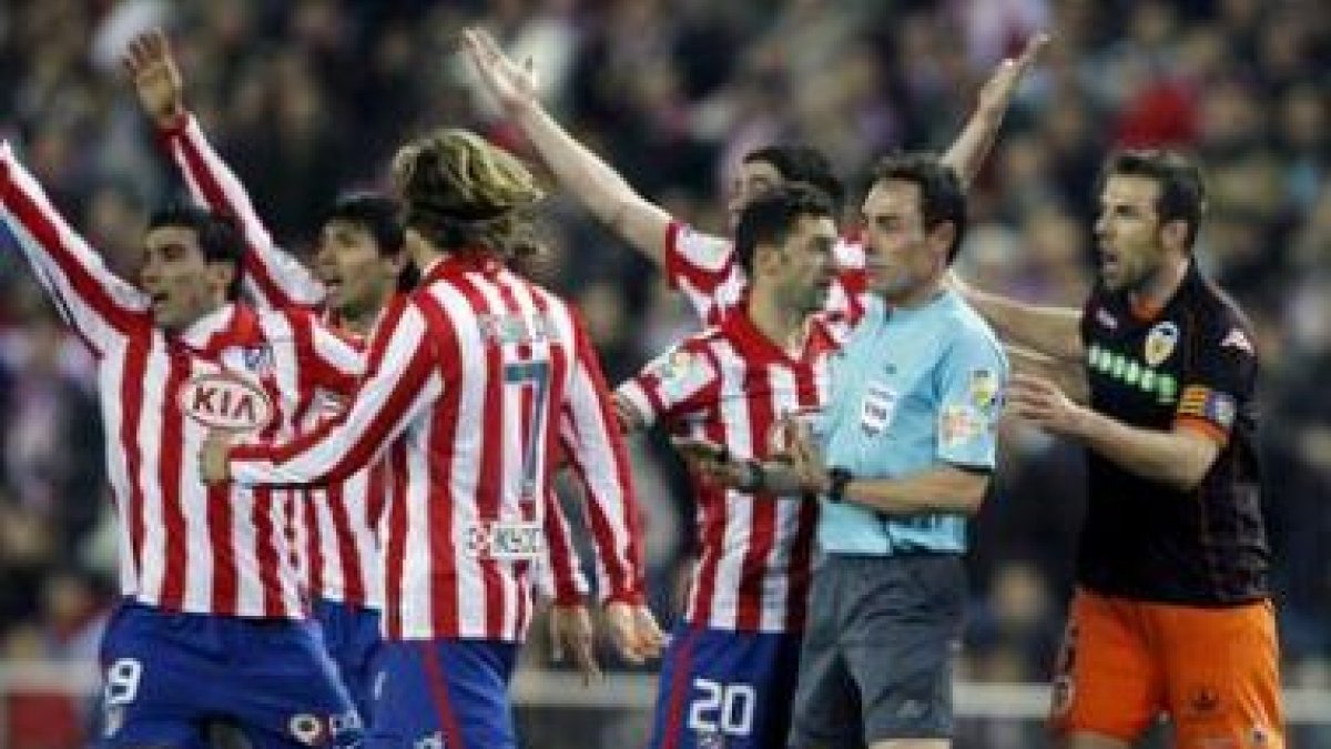 Los jugadores del Atlético protestan a Pérez Burrull.