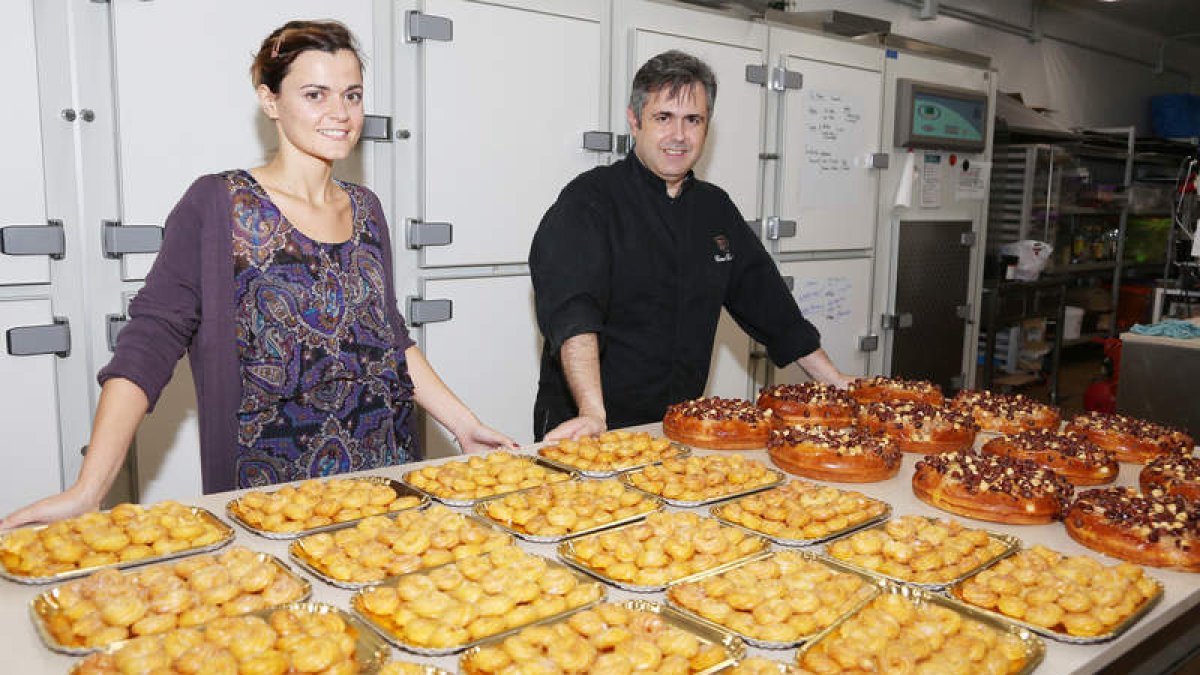 Arriba, Ana, el alma de la Confitería Asturias, y César, su gran chocolatero, en el obrador. Son la segunda generación de confiteros, los ‘herederos de César y Piana. Sobre estas líneas, trabajando las rosquillas