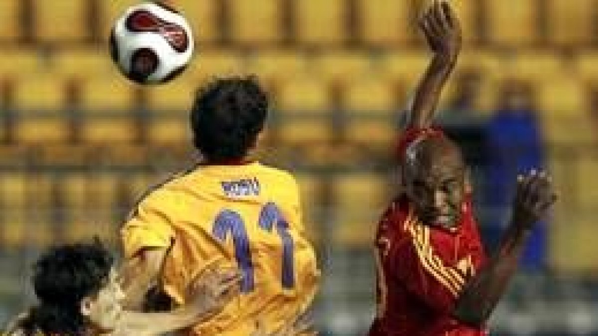 Marcos Senna pelea un balón con los jugadores de la selección rumana Rosu y Ovidiu Petre