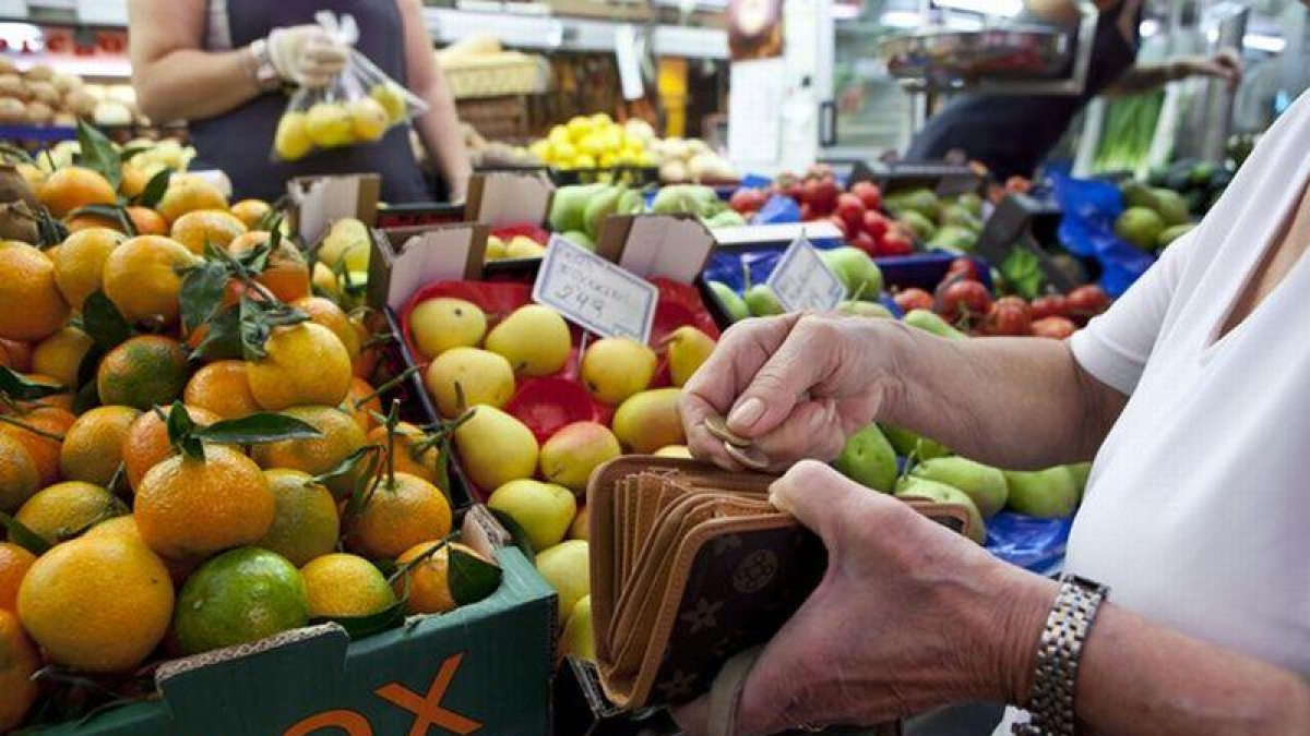 Una mujer llena la cesta de la compra en un mercado de Barcelona.
