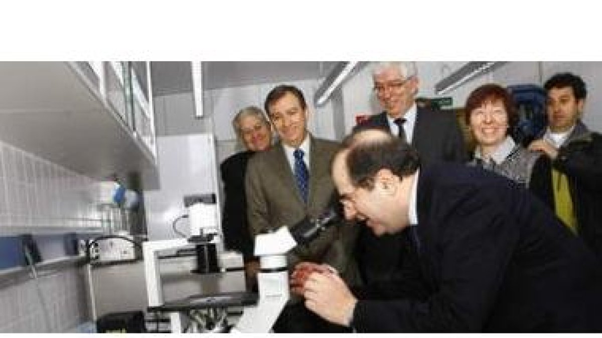 Urbano González, Mateos y Hermida observan como el presidente Herrera mira a través de un microscopi