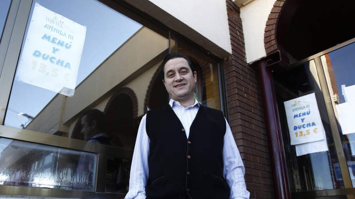 Daniel Carrizo, propietario del Restaurante Avenida, posa junto al cartel que anuncia la oferta.