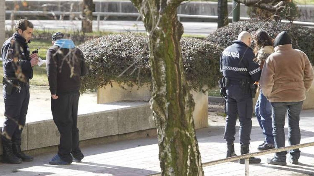 Investigadores de la Policía Nacional buscan la navaja en presencia de los testigos de los hechos.
