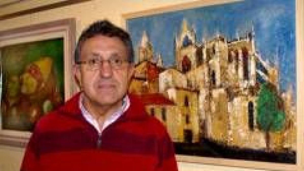 El artista leonés Román Martínez posa junto a dos obras