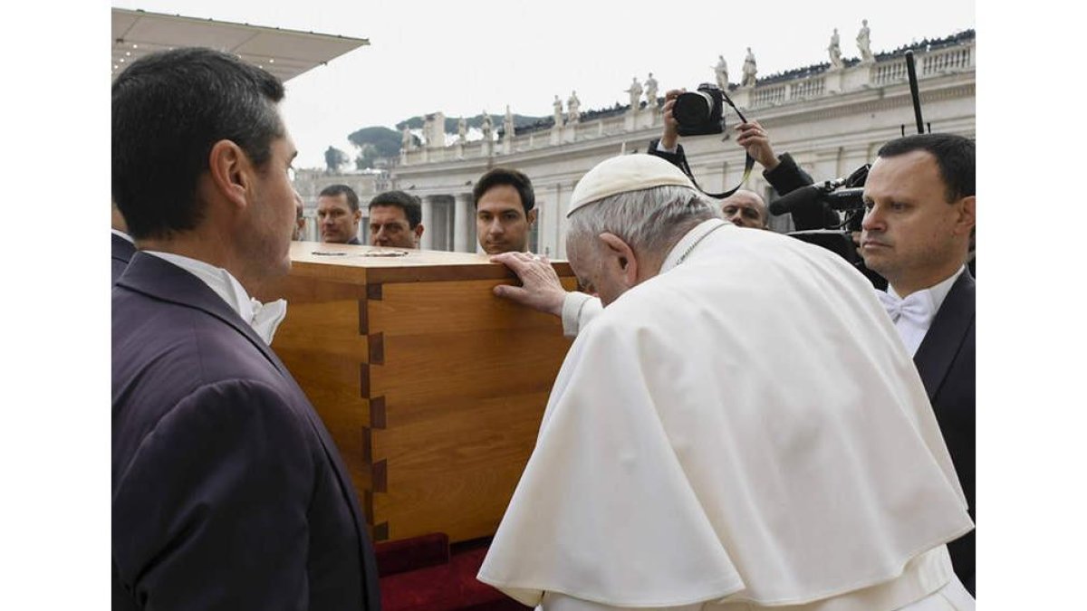 Francisco posa sus manos sobre el féretro de Benedicto XVI. VATICAN MEDIA