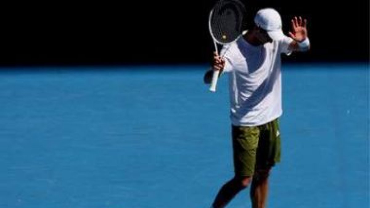 Djokovic levanta la mano en el momento de retirarse de su partido ante Roddick en los cuartos de fin