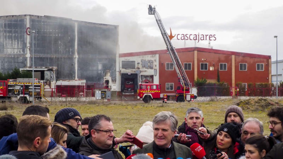 El presidente de Cascajares, Alfonso Jimenez, con la fábrica calcinada detrás. R. GARCIA