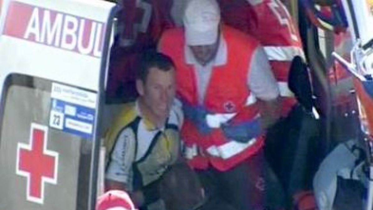 Armstrong, sentado en la cuneta, espera a ser atendido tras sufrir una caída.