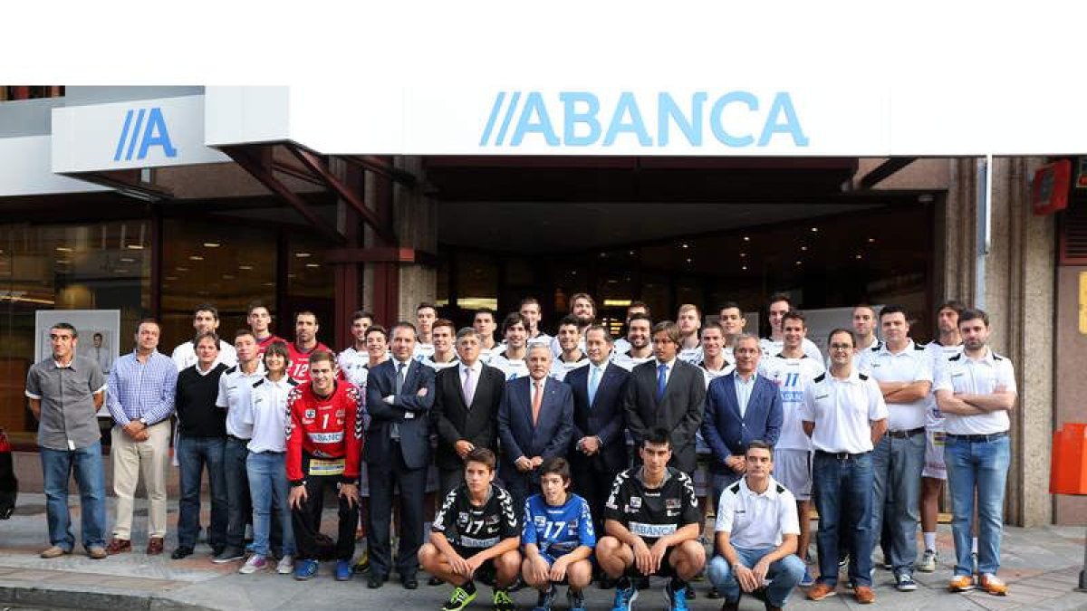 Foto de familia del equipo, plantilla y directivos, con los patrocinadores ante la sede de Abanca.