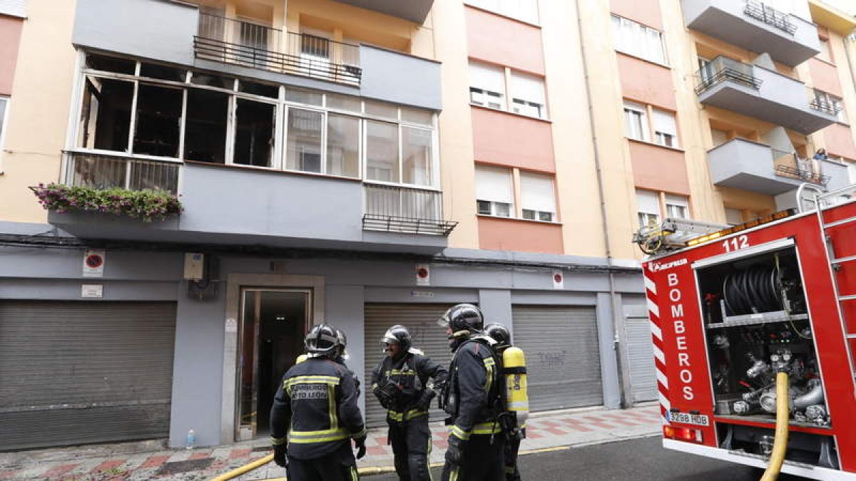 Los bomberos, junto a la vivienda que ardió. MARCIANO PÉREZ