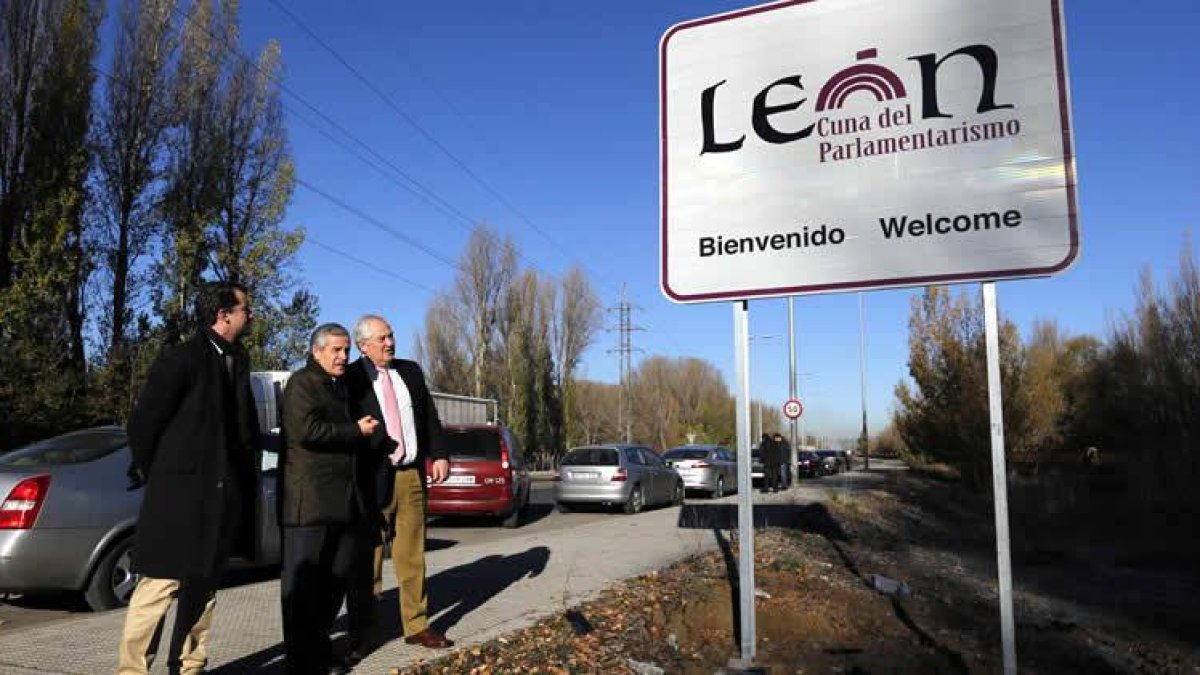 El alcalde, Emilio Gutiérrez, el delegado de la Junta, Guillermo García y el concejal de Cultura, Juan Pablo García Valadés, junto a uno de los carteles que recuerdan la condición de León como cuna del Parlamentarismo.