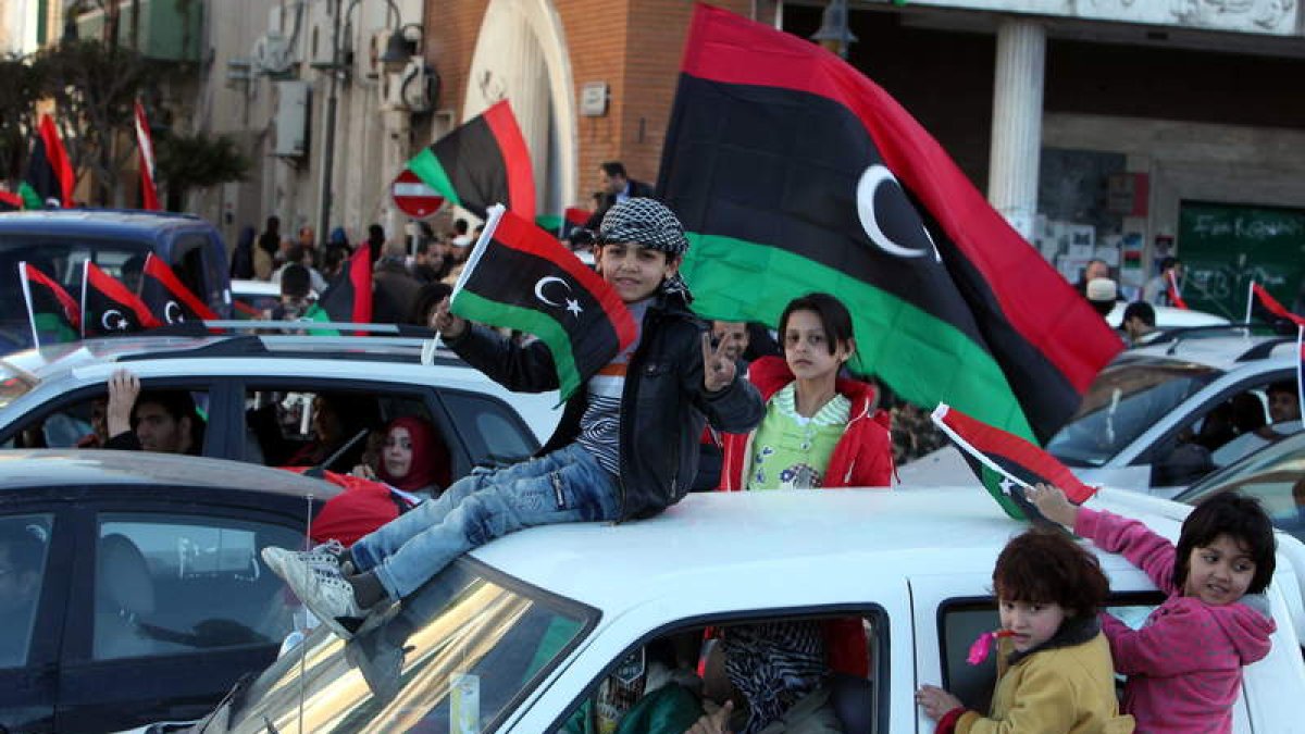 Niños libios ondean la bandera del país en la celebración del aniversario de la revolución.