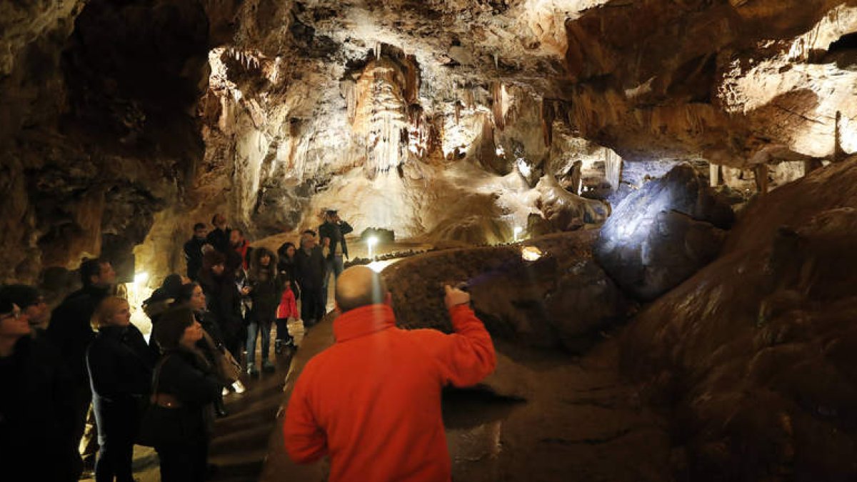 Un grupo de visitantes, en el interior de la cueva, ayer, en el primer día de apertura al público. JESÚS F. SALVADORES