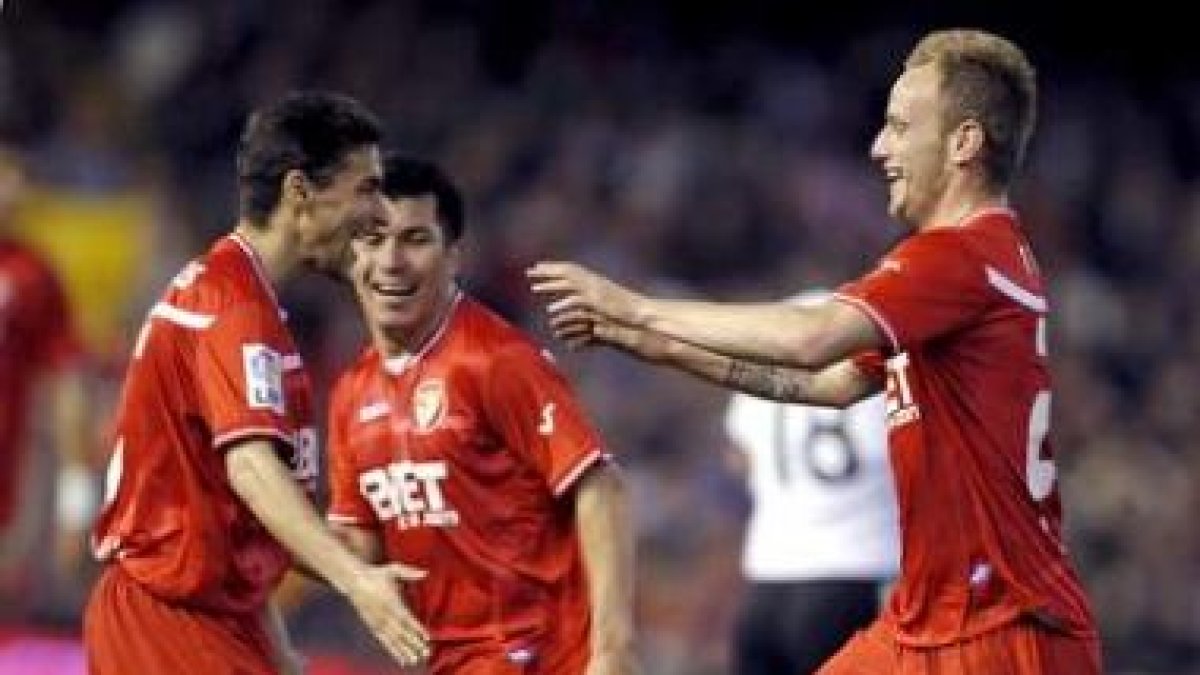 Rakitic (d) celebra su gol con sus compañeros Jesús Navas (i) y el chileno Gary Medel.