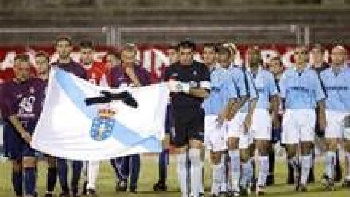 Jugadores del Celta y el Pontevedra portan una bandera gallega con crespón negro