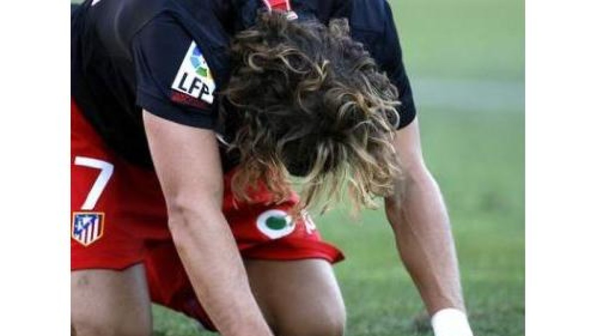 Forlán toma aire tras una falta de un jugador del Málaga.