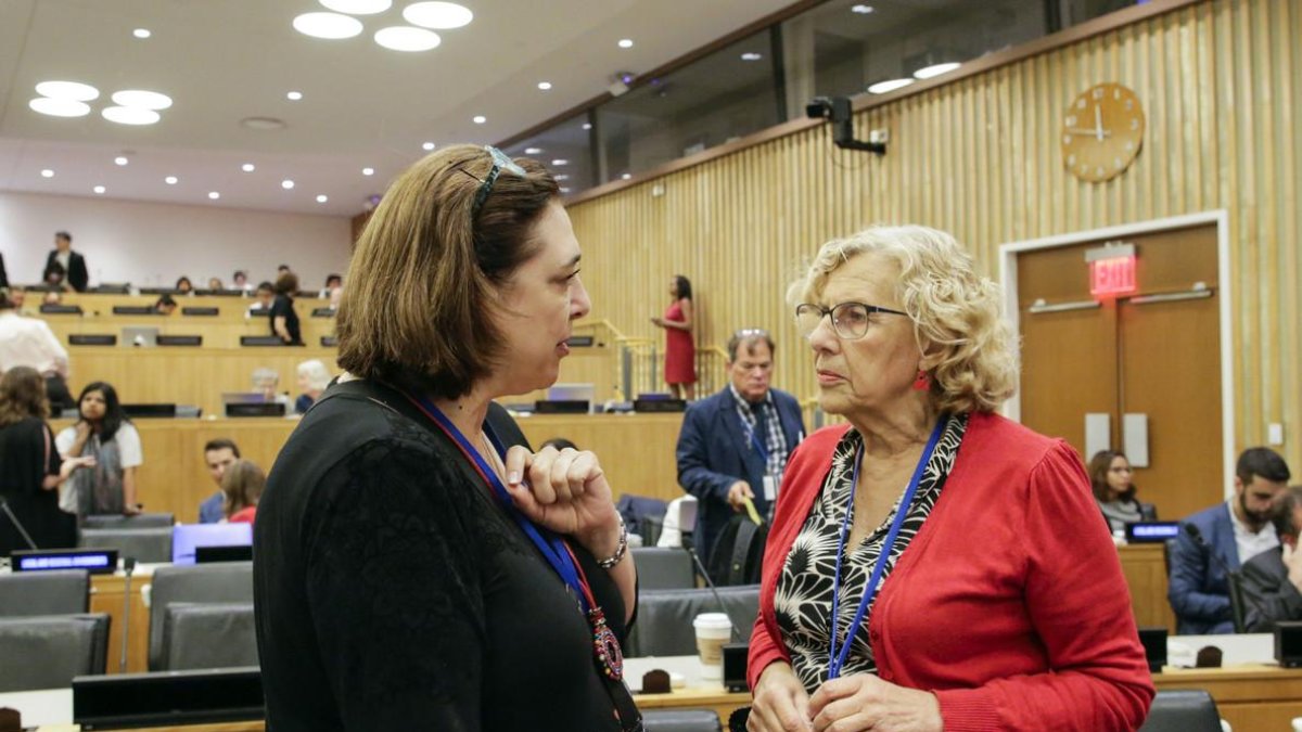 La alcaldesa de Madrid, Manuela Carmena (derecha), habla con una delegada durante su participación en un foro en la sede de la ONU. /