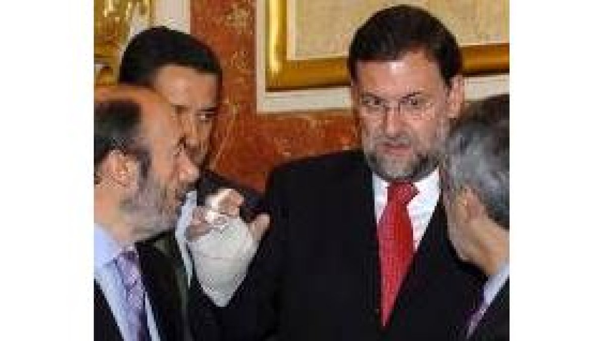 Rajoy charla con otros políticos y les muestra su dedo escayolado
