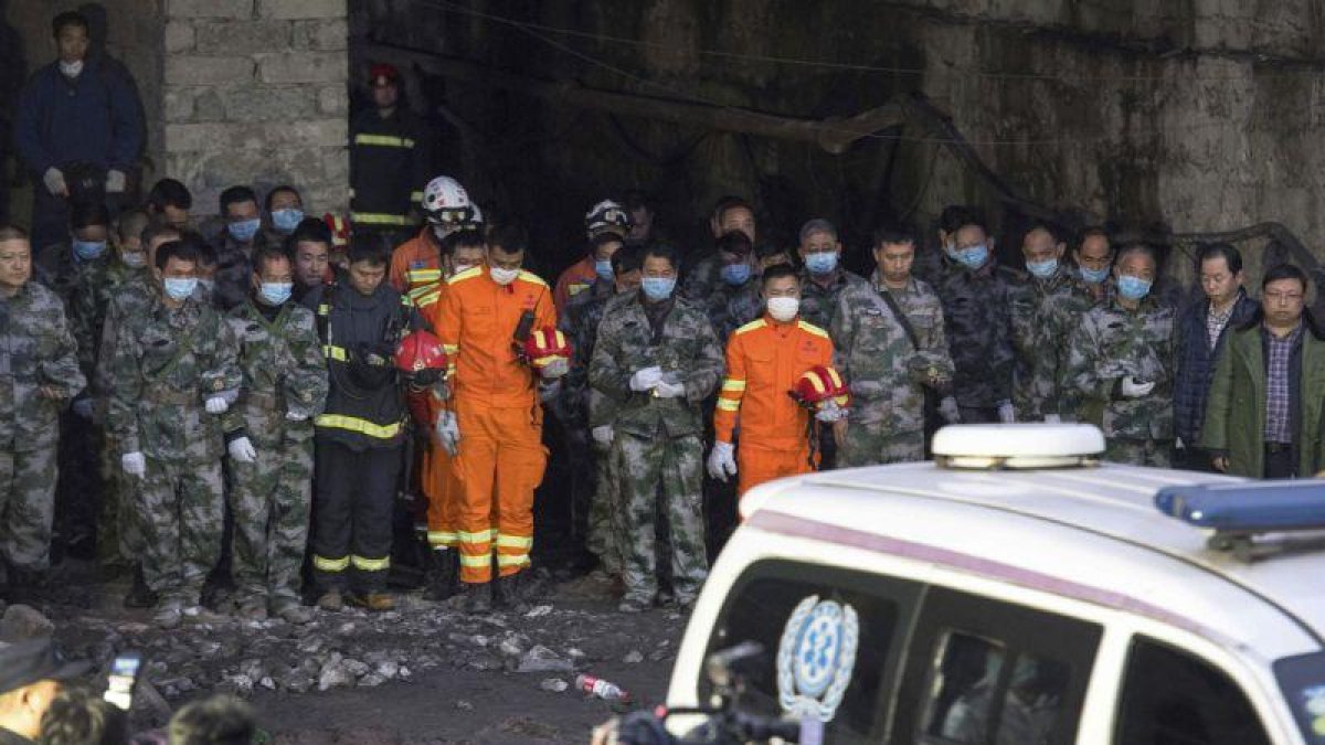 Los equipos de rescate hacen un minuto de silencio por los mineros muertos tras encontrar sus cuerpos sin vida, el martes, en la provincia de Chongqing (China)