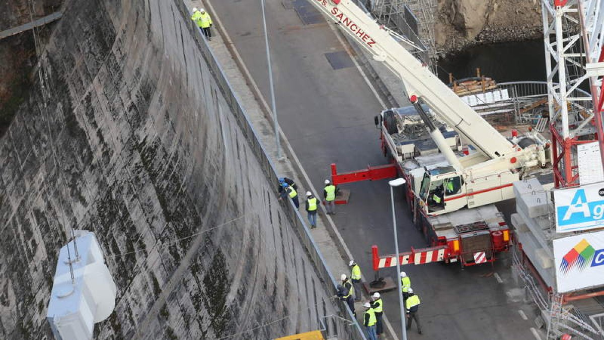 Los operarios bajan una de las piezas de las compuertas con la ayuda de una grúa.