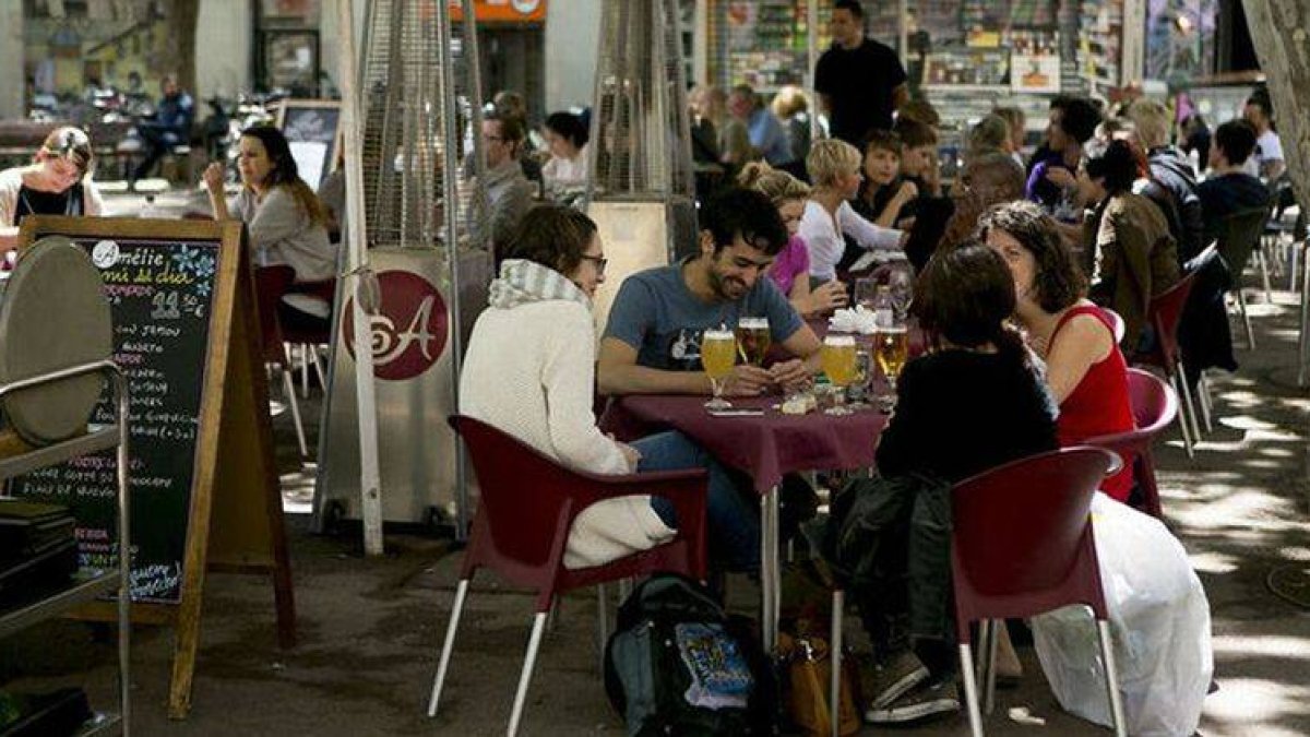 Un grupo de jóvenes disfruta en una terraza.