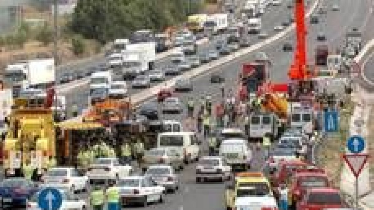 Aspecto del accidente, con el camión volcado a la izquierda y uno de los autobuses a la derecha