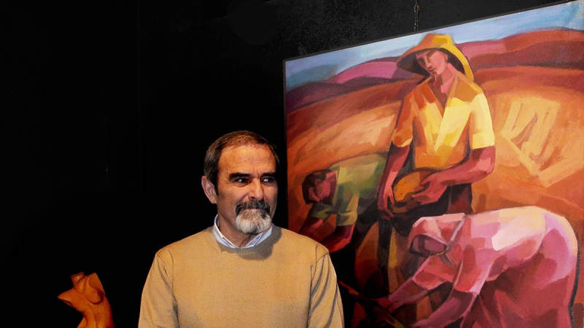 El artista Guerra Calle posa junto a dos de sus obras.