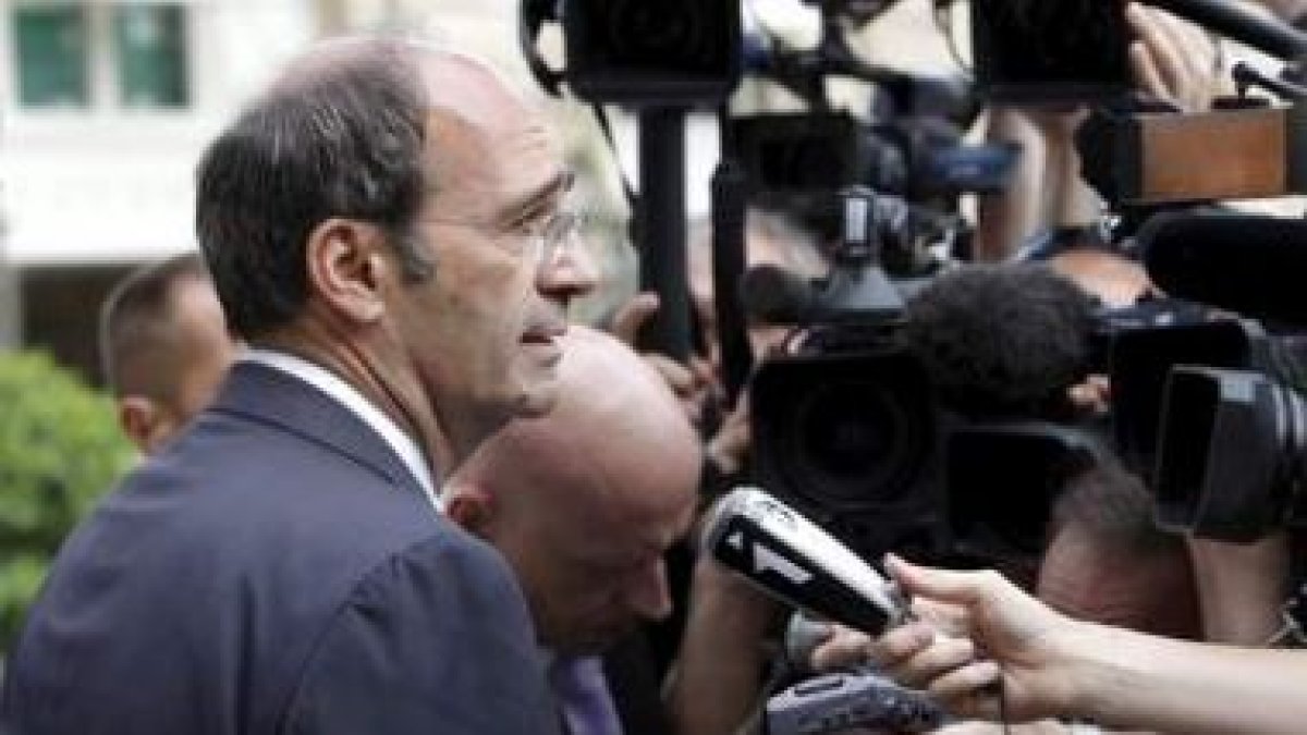 El ministro de Trabajo francés, Eric Woerth, atiende a los medios tras su dimisión.