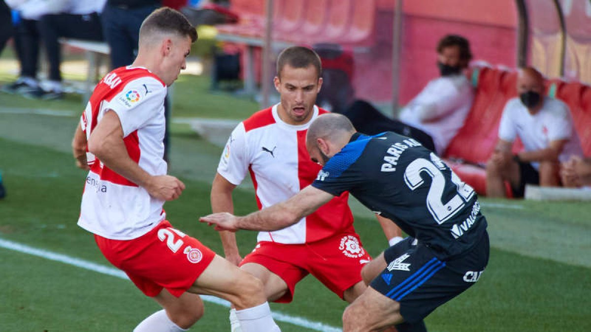 Paris Adot, presionado por dos rivales en el partido del último sábado en Montilivi ante el Girona FC. EDDY KELELE