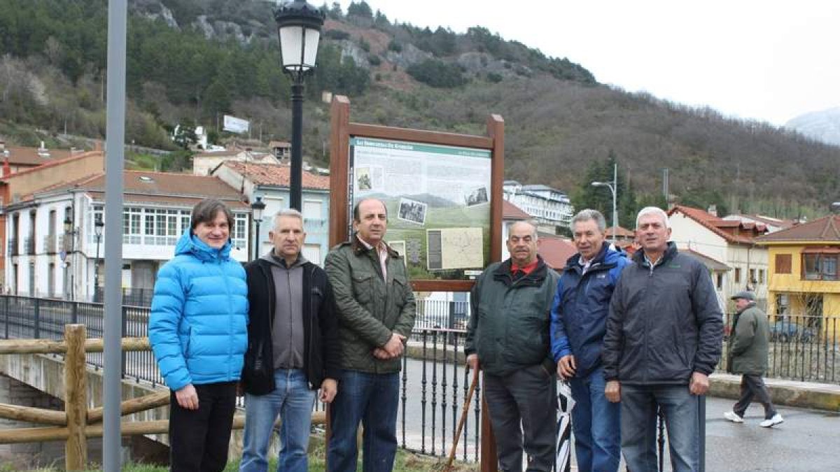 Las autoridades municipales posan ante un cartel temático de la ruta bélica.