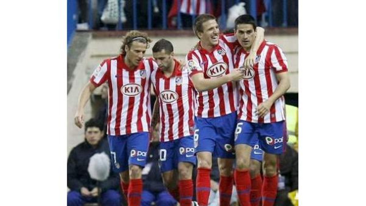 Juanito (d) es felicitado por sus compañeros tras conseguir el primer gol del Atlético de Madrid.