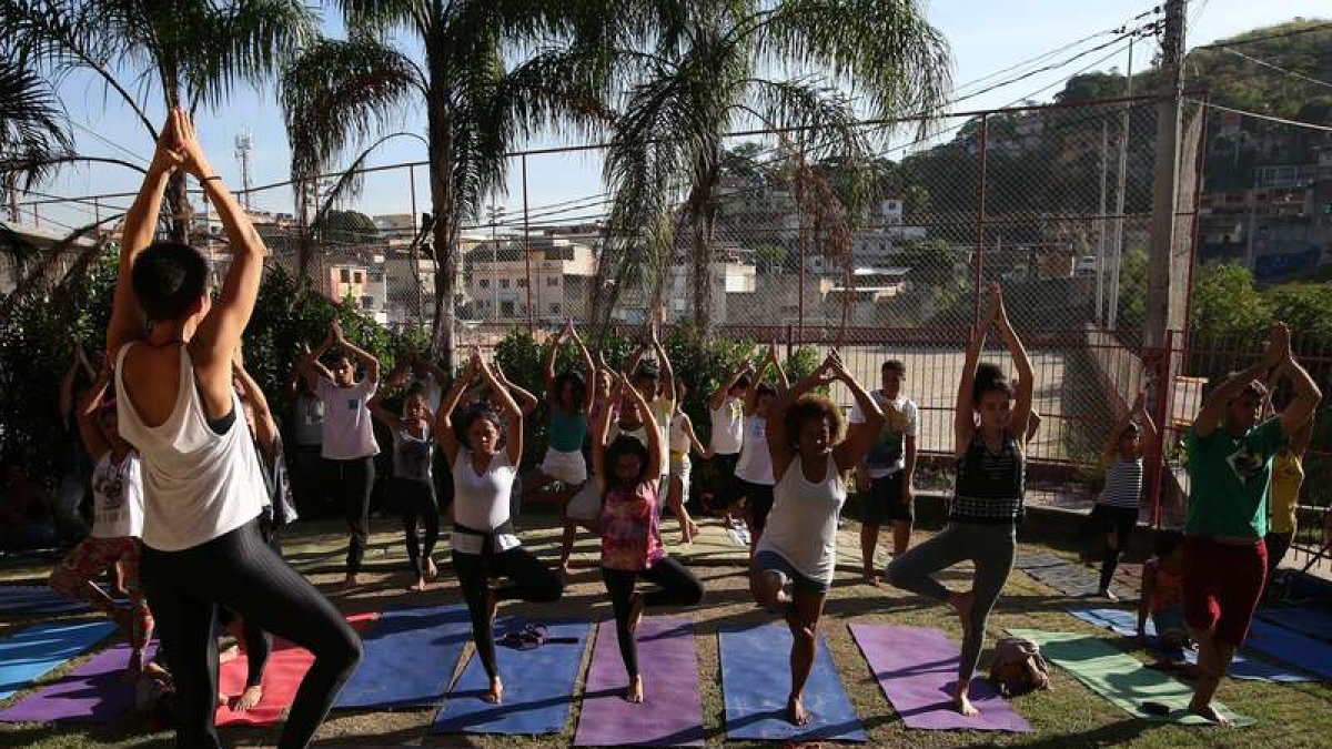 Con las favelas detrás, los practicantes realizan la postura del árbol. MARCELO SAYAO