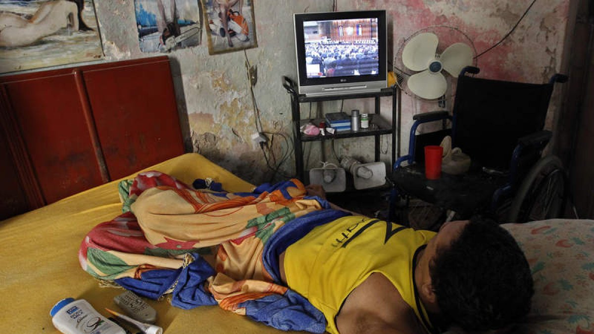 Un ciudadano cubano contempla la renuncia de Raúl Castro por la televisión. ERNESTO MASTRASCUSA
