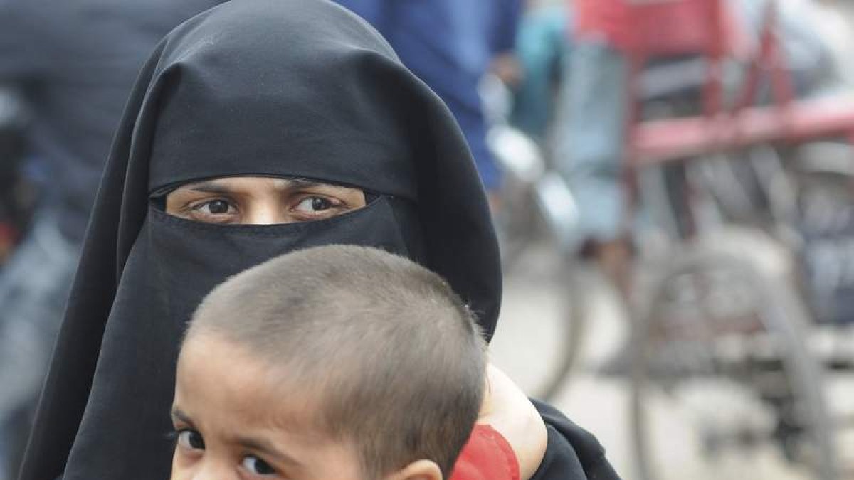 Una mujer musulmana sujeta a su hijo mientras camina por las calles de la ciudad de Nueva Delhi. EFE