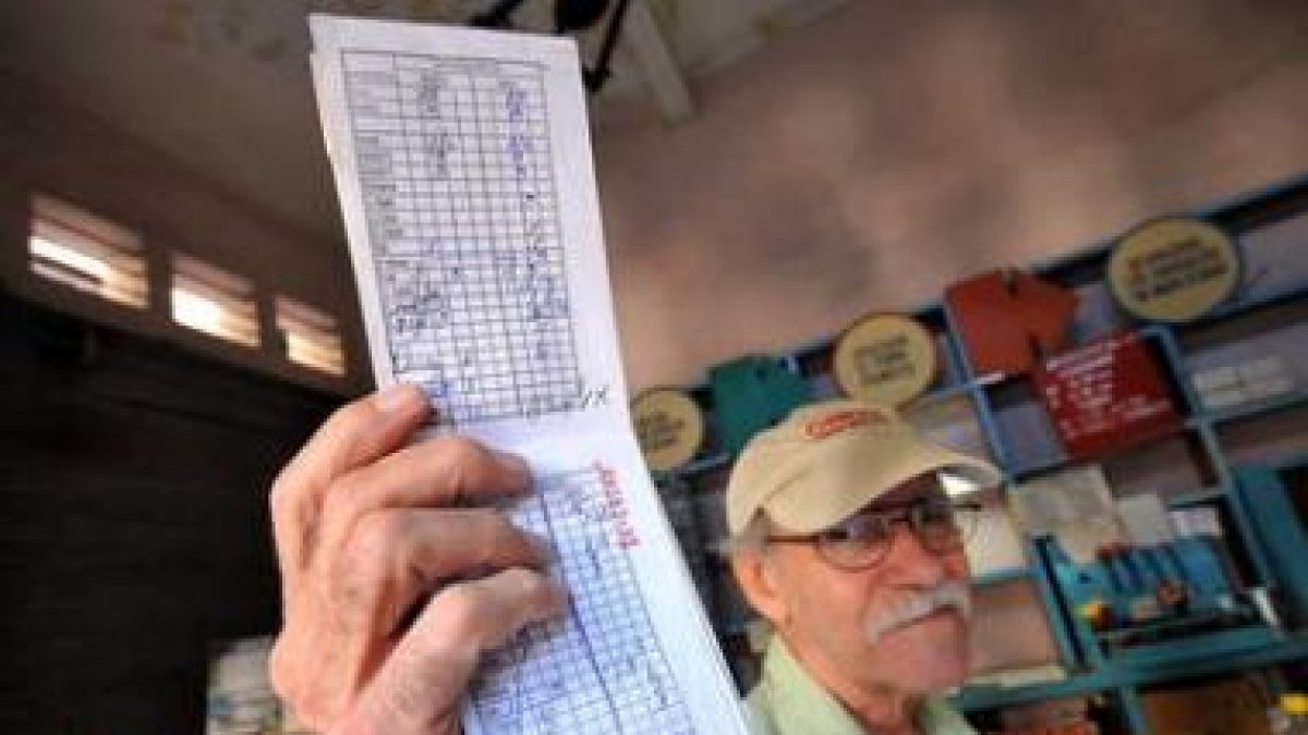 Un cubano muestra su cartilla de racionamiento.