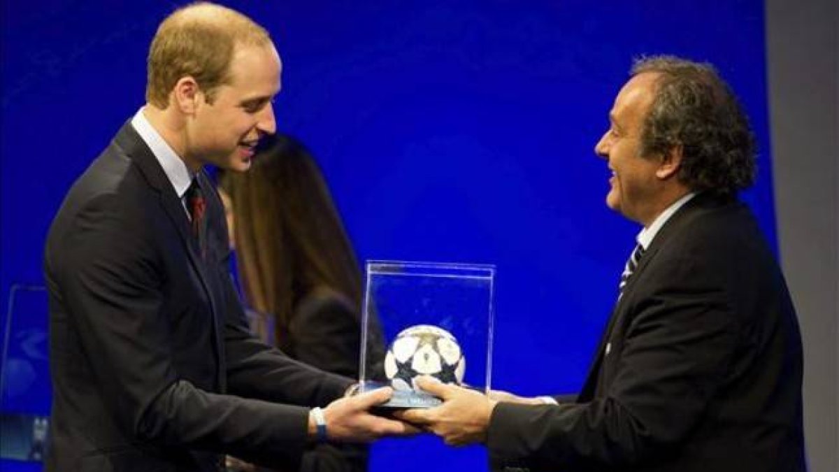 l príncipe Guillermo de Inglaterra (izquierda) recibe un balón de manos del presidente de la UEFA, Michael Platini, durante el 37º Congreso Ordinario de la UEFA.
