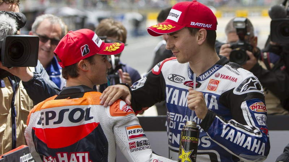 Los españoles Jorge Lorenzo y Dani Pedrosa se saludan tras clasificarse primero y segundo.