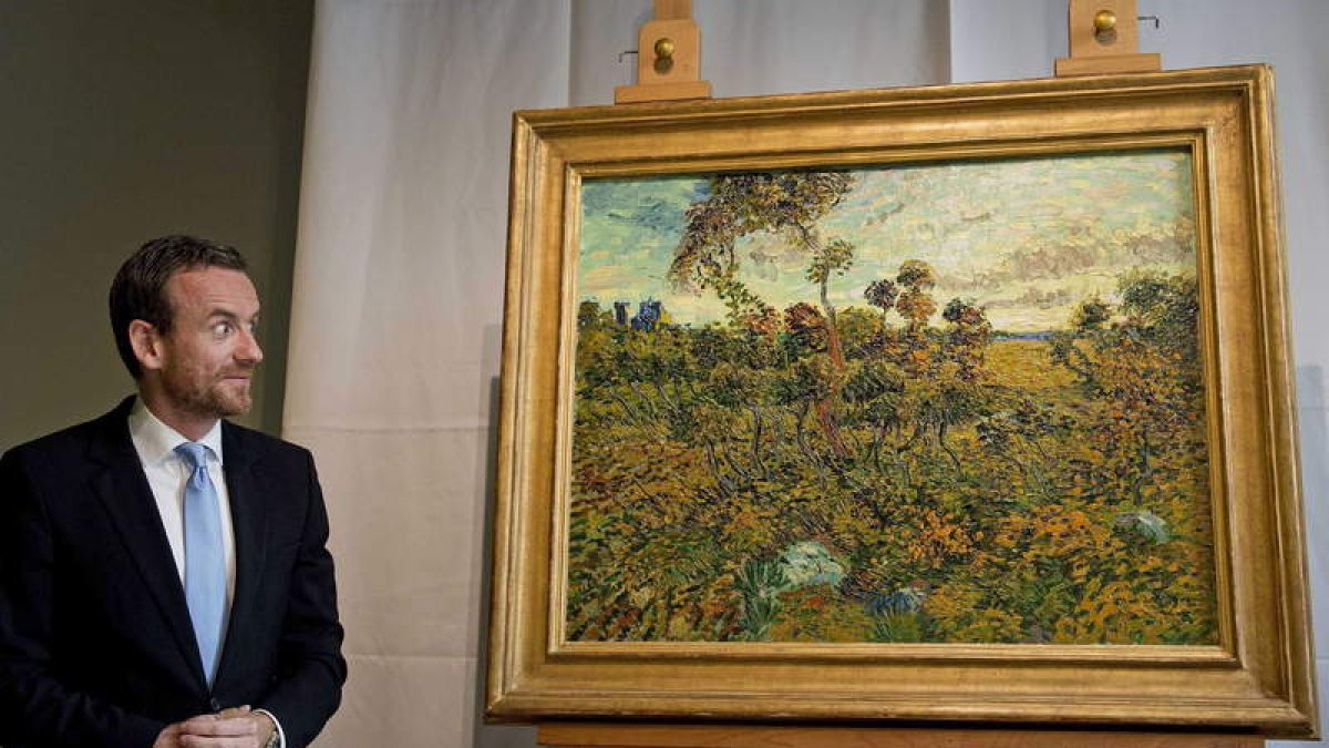 El director del Museo Van Gogh, Alex Rüger, con la nueva obra del artista, ‘Puesta de sol en Montmajour’.