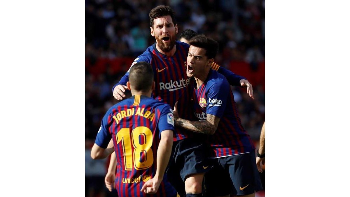 Messi celebra con Jordi Alba y Coutinho uno de sus tres goles ante el Sevilla. JULIO MUÑOZ