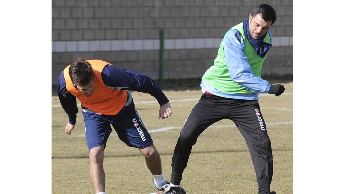 Esaú, a la izquierda, se esfuerza en el entrenamiento ante el técnico Luis Cembranos.