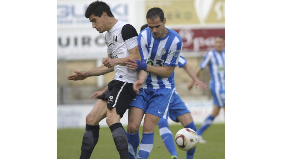 El blanquiazul Javi Navarro, a la derecha, pelea por la posesión del balón con Barranco en un lance del partido disputado en el Stadium Gal de Irún.