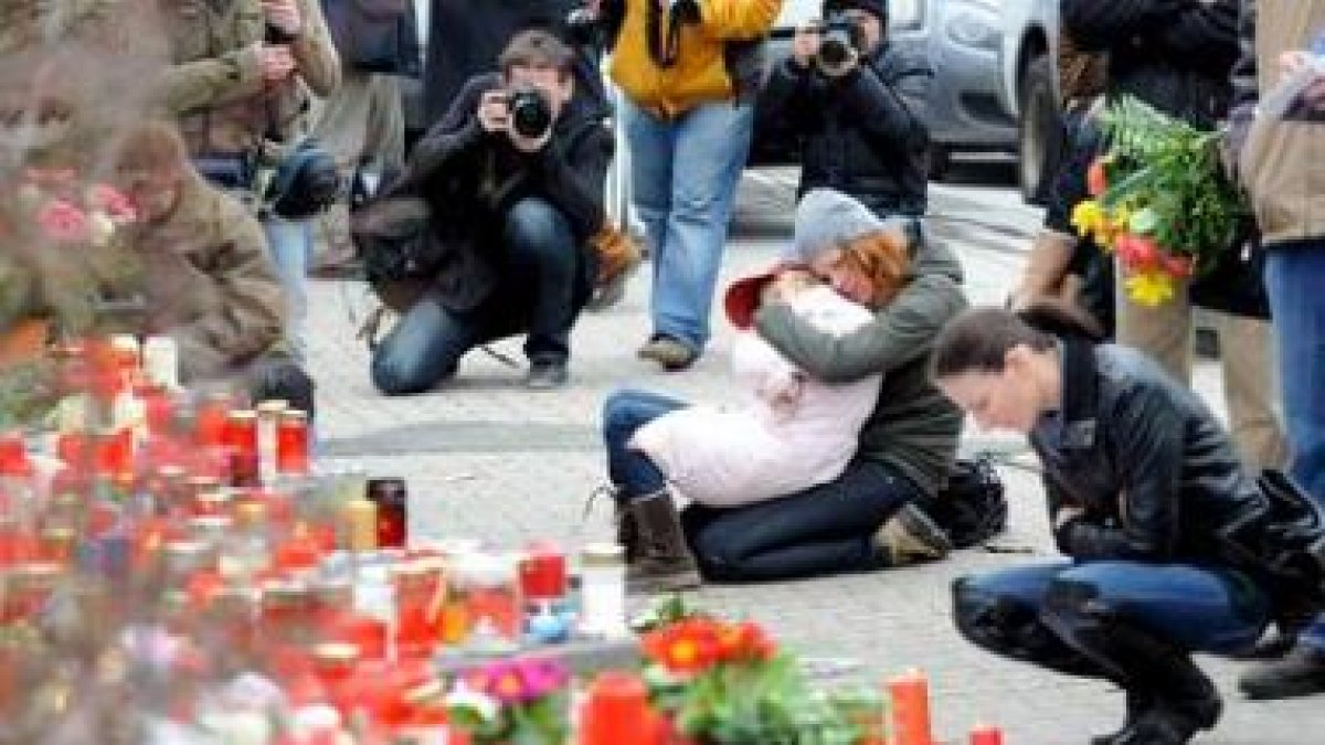 Varias personas se muestran apenadas ante el altar montado en el exterior de la escuela de Albertvil