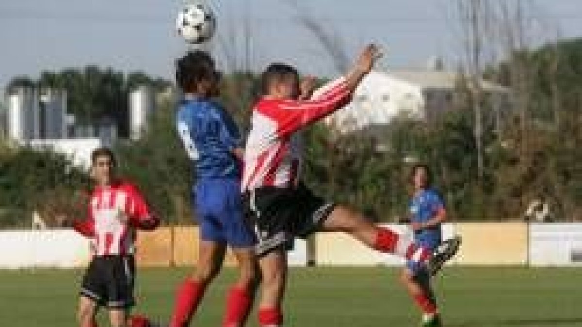 Ministro, con el ocho, despeja de cabeza un centro al que intentaba llegar el jugador local Arroyo