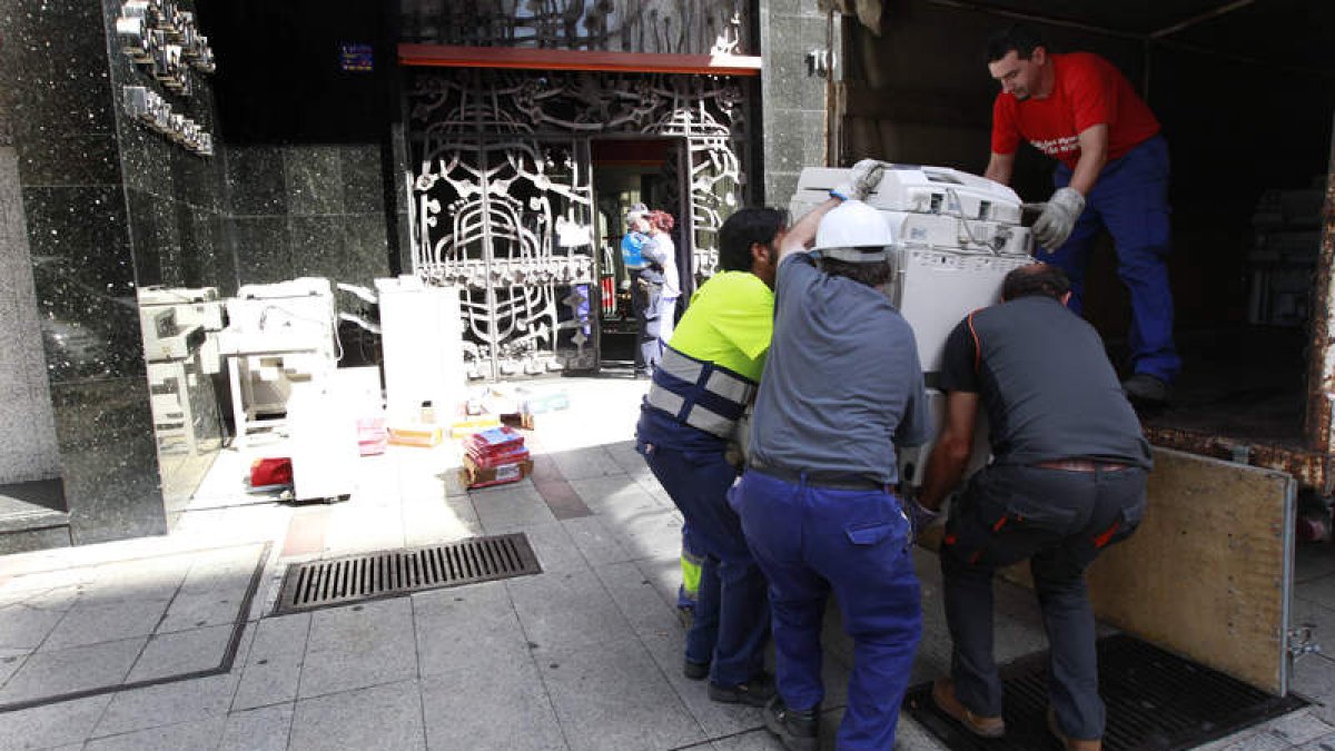 Operarios trasladan material de la sede municipal del ayuntamiento de León tras el incendio.